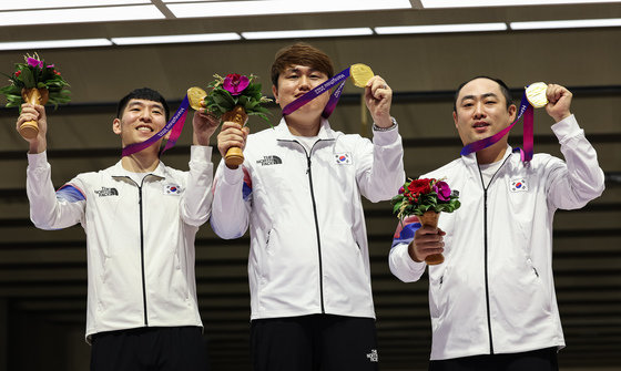 곽용빈(왼쪽부터), 정유진, 하광철이 26일 중국 항저우 푸양 인후 스포츠센터에서 열린 2022 항저우 아시안게임 사격 남자 10m 러닝타깃 혼합 단체전 시상식에서 금메달을 들고 포즈를 취하고 있다. 2023.9.26 뉴스1