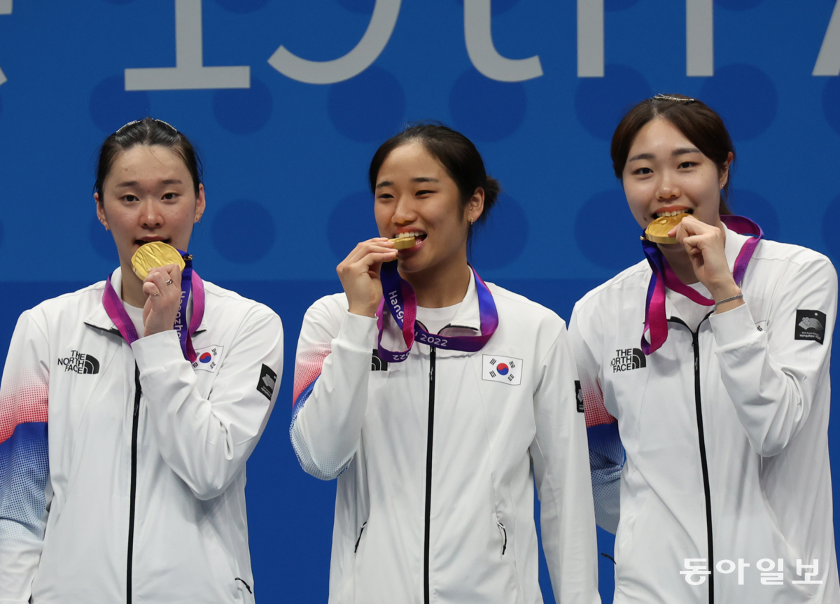 1일 중국 항저우 빈장체육관에서 열린 2022 항저우 아시안게임 배드민턴 여자 단체전에서 한국이 중국을 꺾고 금메달을 차지했다. 시상식에서 선수들이 금메달을 깨물어보고 있다. 김재명 기자 base@donga.com