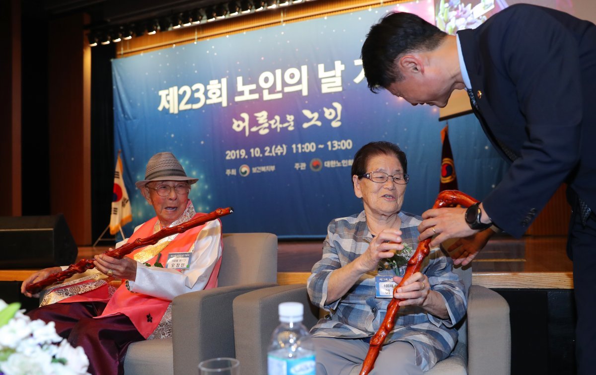 김강립 보건복지부 차관이 2일 오전 서울 중구 대한상의회관에서 열린 ‘제23회 노인의 날 기념식‘에서 올해 100세를 맞은 오창민, 이정직 어르신에게 문재인 대통령 내외의 축하카드와 청려장을 선물하고 있다. 2019.10.2/뉴스1