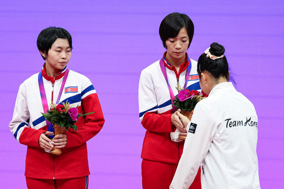 신유빈이 2일 중국 항저우 궁수 캐널 스포츠파크 체육관에서 열린 2022 항저우 아시안게임 탁구 여자 복식 시상식에서 시상대에 오르며 북한 차수영-박수경과 악수하고 있다. 2023.10.2/뉴스1