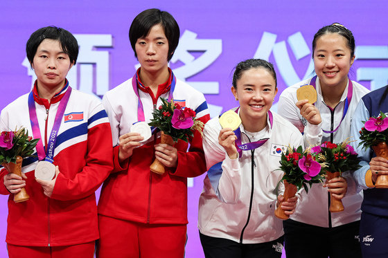 신유빈-전지희와 북한 차수영-박수경이 2일 중국 항저우 궁수 캐널 스포츠파크 체육관에서 열린 2022 항저우 아시안게임 탁구 여자 복식 시상식에서 나란히 시상대에 올라 메달을 들어보이고 있다. 2023.10.2/뉴스1