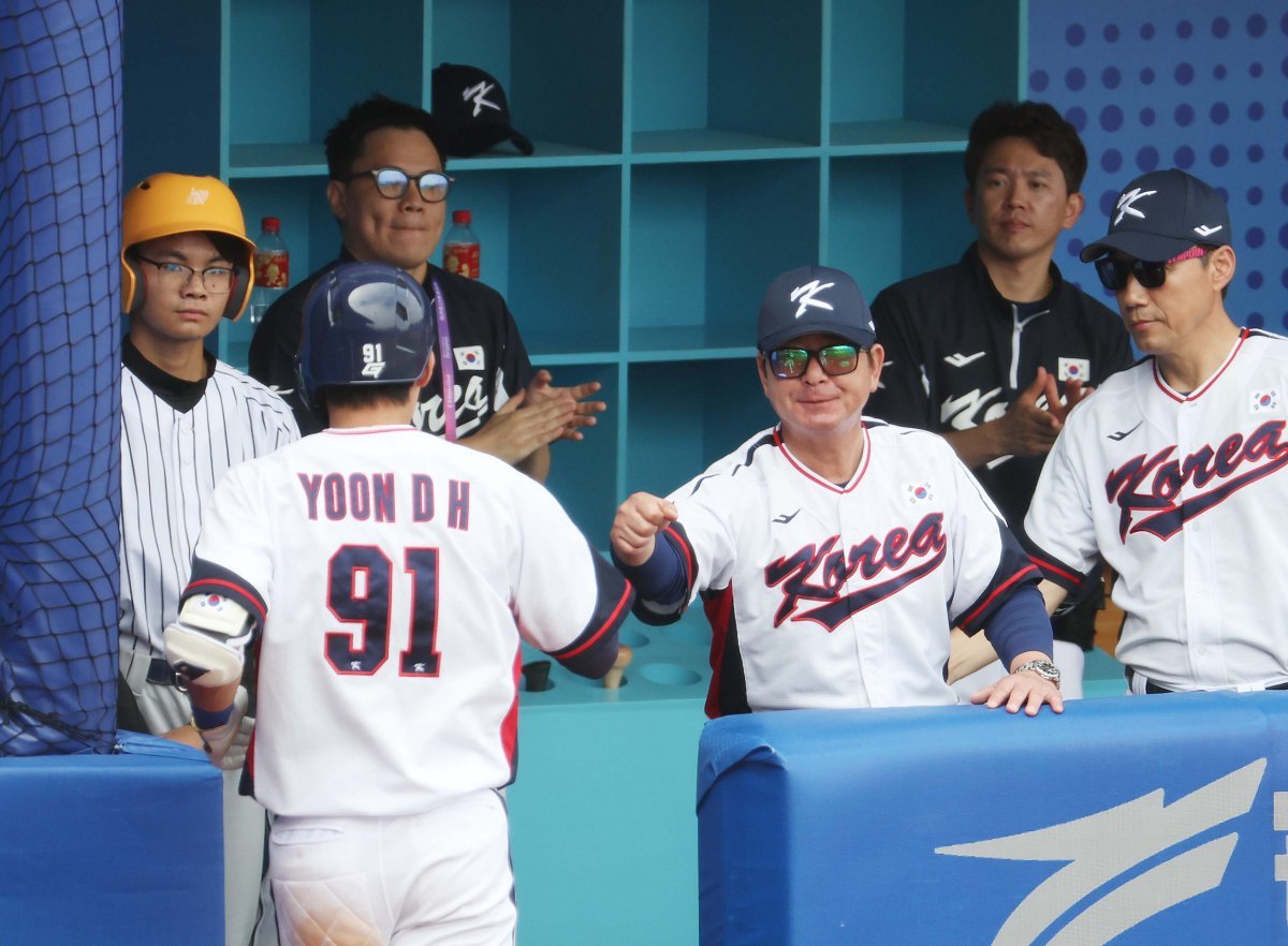 류중일 한국 대표팀 감독(오른쪽)이 3일 태국전에서 홈런을 친 윤동희와 주먹을 마주치고 있다.   사오싱=뉴시스
