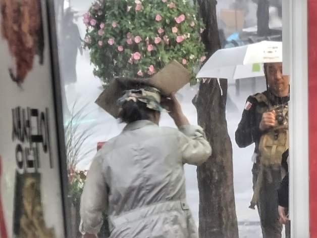 4일 오후 갑작스러운 소나기에 서울 서대문구 연세대 앞에서 한 시민이 박스로 비를 가린 채 걷고 있다. 2023.10.4/뉴스1
