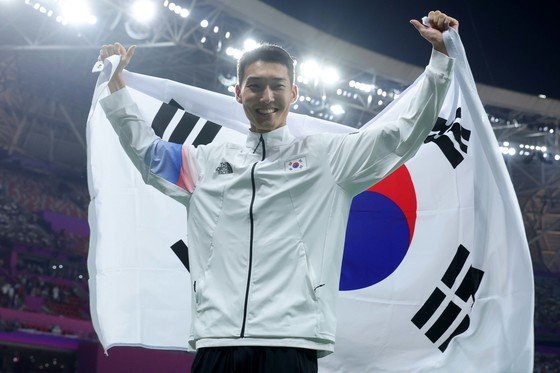 우상혁이 4일 중국 항저우 올림픽 스포츠센터 스타디움에서 열린 2022 항저우 아시안게임 남자 높이뛰기 결선에서 은메달을 확정지은 뒤 태극기를 펼쳐들고 있다. (공동취재) 2023.10.4/뉴스1 ⓒ News1