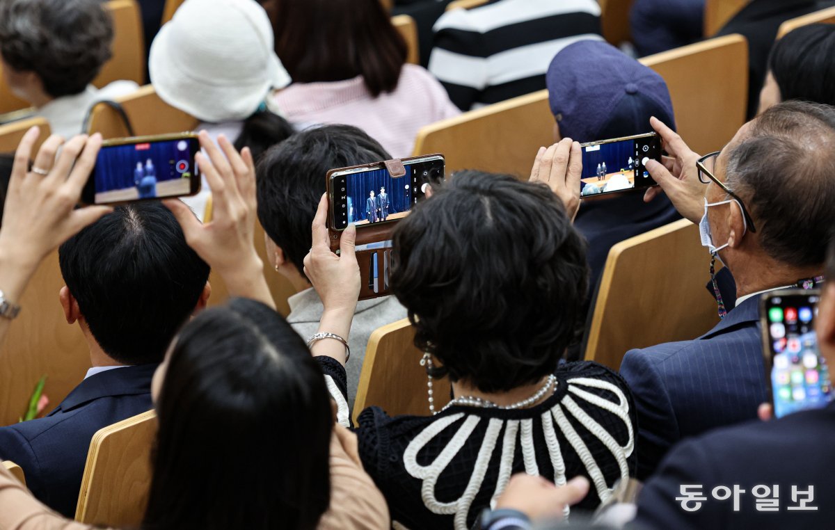 신임 법관 임명식에서 한 가족이 일제히 스마트폰을 든 채 임명장을 받아든 신임 판사를 촬영하고 있다. 이한결 기자 always@donga.com