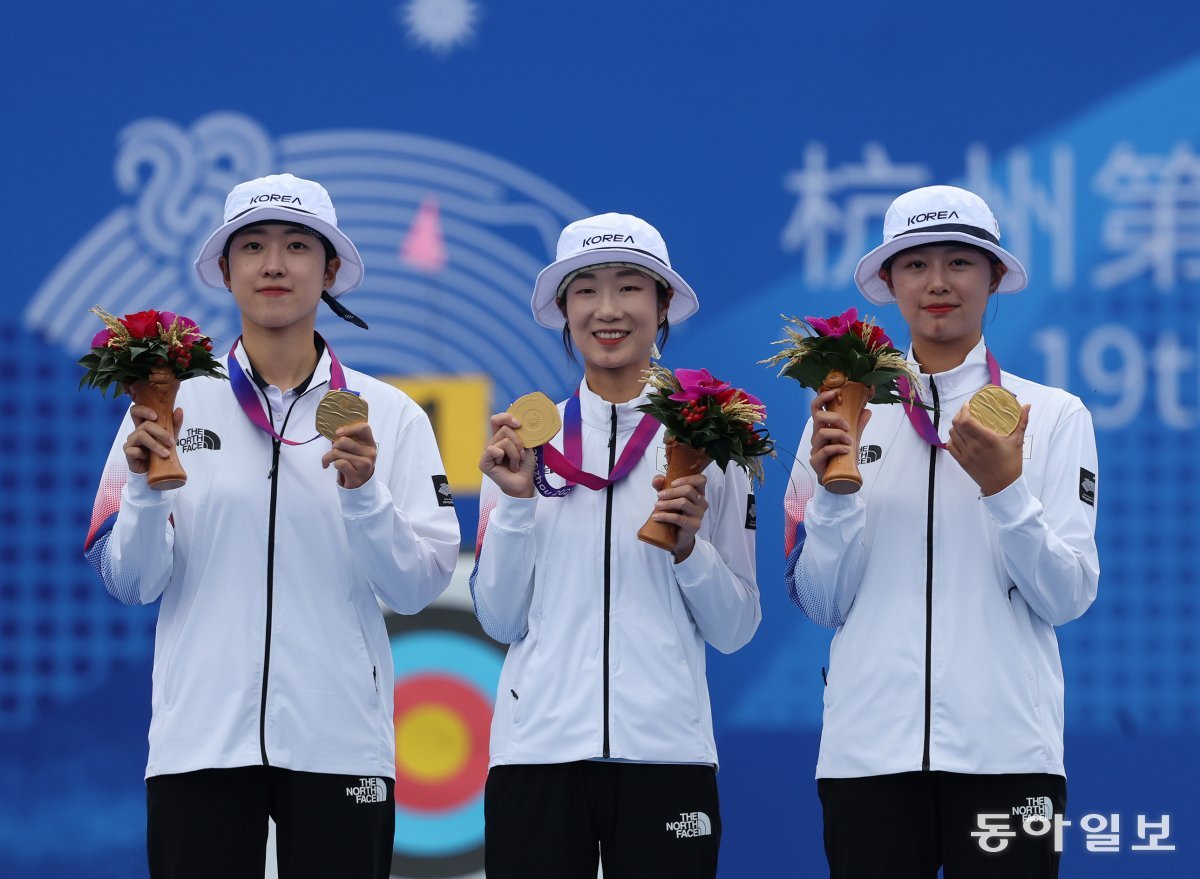 개최국 中 격파  안산-최미선-임시현 한국 여자 양궁 대표팀이 6일 항저우 아시안게임 리커브 단체전 결승에서 중국을 꺾고 금메달을 차지하면서 대회 7연패를 달성했다. 여자 대표팀 안산 최미선 임시현(왼쪽부터)이 시상식에서 목에 건 금메달을 들어 보였다. 항저우=김재명 기자 base@donga.com