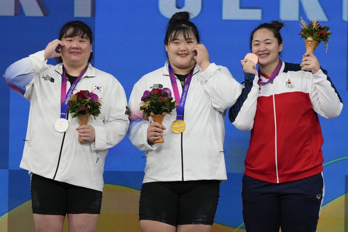 From left, Silver medalist Younghee Son and gold medalist Hyejeong Park of South Korea and bronze medalist Duangaksorn Chaidee of Thailand pose during ceremonies at the women‘s +87Kg weightlifting event at the 19th Asian Games in Hangzhou, China, Saturday, Oct. 7, 2023. (AP Photo/Aaron Favila)