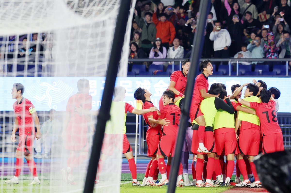 한국이 7일 중국 항저우 황룽 스포츠센터에서 열린 일본과의 아시안게임 남자축구 결승전에서 2-1로 승리한 뒤 선수단이 끌어안고 기쁨을 만끽하고 있다. 한국은 남자축구 최초의 아시안게임 3연패를 달성했다. 항저우=뉴스1