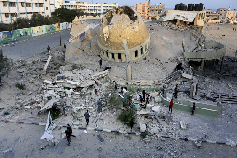 8일(현지 시간) 팔레스타인 무장단체 하마스가 장악하고 있는 가자지구에서 이스라엘군의 대규모 보복 공습으로 파괴된 이슬람 사원 모스크를 사람들이 지켜보고 있다. 가자지구=AP 뉴시스