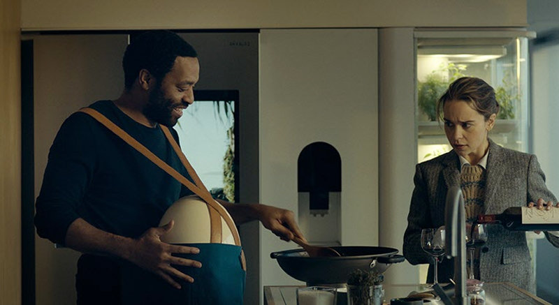 영화 ‘팟 제너레이션’에서 레이첼(에밀리아 클라크·오른쪽)은 아기가 든 인공 자궁인 ‘팟’을 배에 둘러멘 남편 앨비(추이텔 에지오포)를 보며 어색함과 이질감을 느낀다. 왓챠 제공