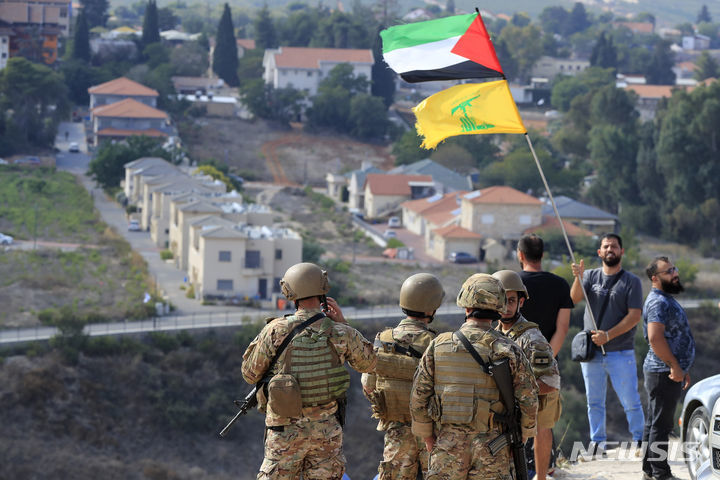 레바논과 이스라엘 국경 마을 크파르 킬라에서 9일 한 남성이  팔레스타인과 헤즈볼라 깃발을 흔들고 있다.  크파르 킬라=AP 뉴시스