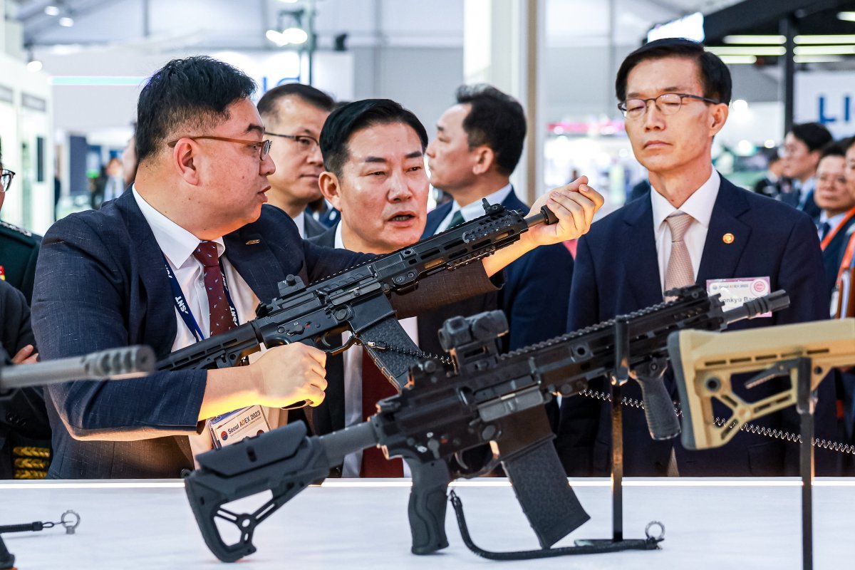 SNT모티브 특수 개발 영업 담당 손주현 이사(왼쪽)가 신원식 국방부 장관에게 K13 기관단총에 관해 설명하고 있다. SNT 그룹 제공