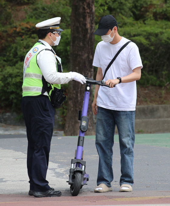 최근 전동퀵보드 관련 사고가 늘어가고 있는 가운데 지난 5월25일 대전 유성구 충남대학교 앞에서 유성경찰서 소속 경찰관들이 전동퀵보드 헬멧 착용 캠페인을 하고 있다. 2022.5.25 뉴스1