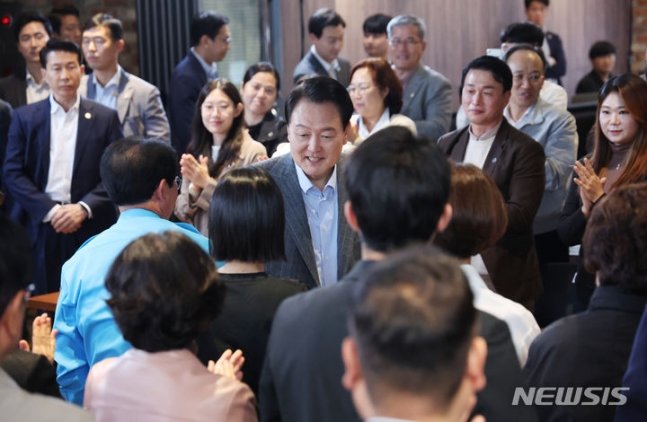 윤석열 대통령이 1일 서울 마포구 한 카페에서 열린 제21차 비상경제민생회의에 입장하며 참석자들과 인사하고 있다. 이날 회의에는 주부, 회사원, 소상공인 등 다양한 직업과 연령대의 국민 60여 명이 참석했다. (대통령실통신사진기자단) 2023.11.01.