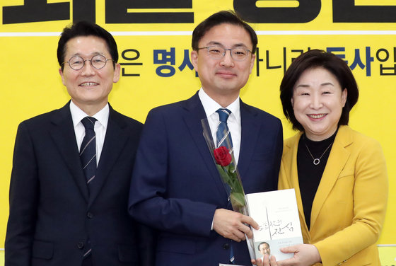 심상정 정의당 대표와 윤소하 원내대표가 8일 서울 여의도 국회에서 열린 21대 국회의원 총선거 비례대표 후보자 선출보고회에서 비례대표 6번에 선정된 신장식 당 사법개혁특위원장(가운데) 에게 장미꽃과 노회찬 회고록을 전달하고 있다. 2020.3.8 뉴스1