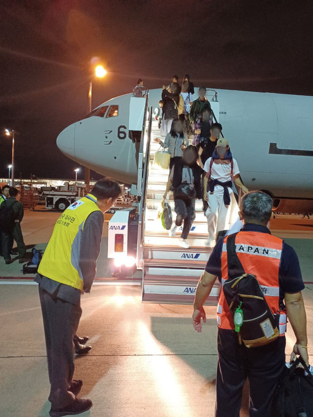 지난달 21일 주일 한국대사관 관계자들이 도쿄 하네다 공항에서 일본 수송기를 이용해 이스라엘을 빠져나온 한국인들을 맞이하고 있다. 외교부 제공