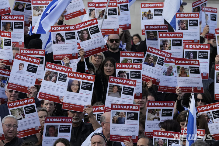 22일(현지시각) 영국 런던의 트래펄가 광장에 모인 친이스라엘 시위대가 가자지구에서 인질로 잡힌 이스라엘 사람들의 사진과 이름이 적힌 손팻말을 들고 그들의 석방을 요구하고 있다. 2023.10.23.[런던=AP/뉴시스]