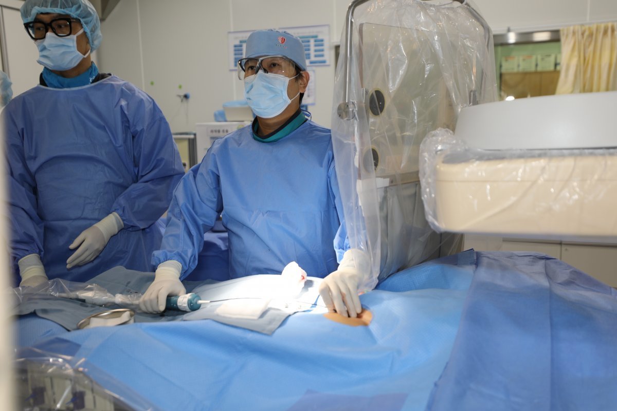인하대병원 박상돈 교수(심장내과·오른쪽)가 대동맥판막 협착증 환자에게 ‘경피적 대동맥판막 치환술’(타비 시술)을 하고 있다. 인하대병원 제공