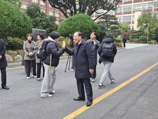 2024 대학수학능력시험이 치러진 16일 부산진구 경남공업고등학교 앞에서 하윤수 부산교육감이 수험생과 하이파이브를 하고 있다. 뉴스1