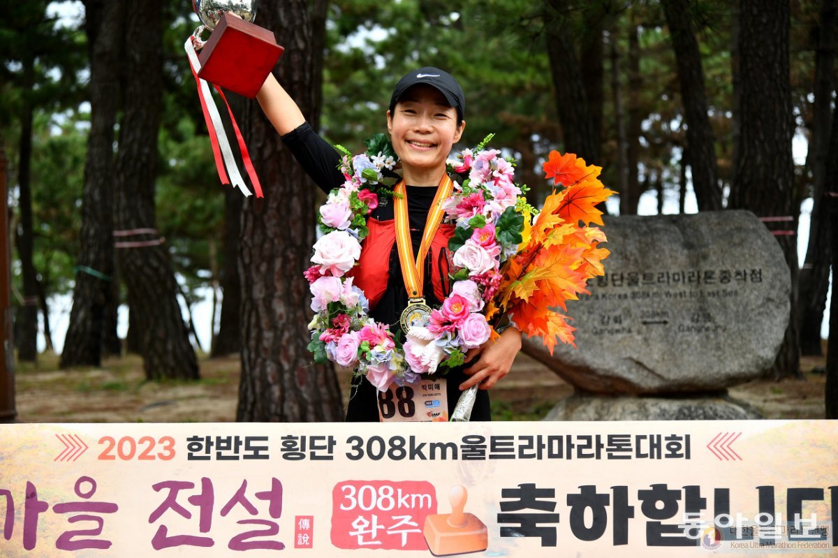 박미애 씨가 10월 5일부터 8일까지 열린 2023 한반도 횡단 308km를 완주한 뒤 축하 화환을 걸고 기뻐하고 있다. 박미애 씨 제공.