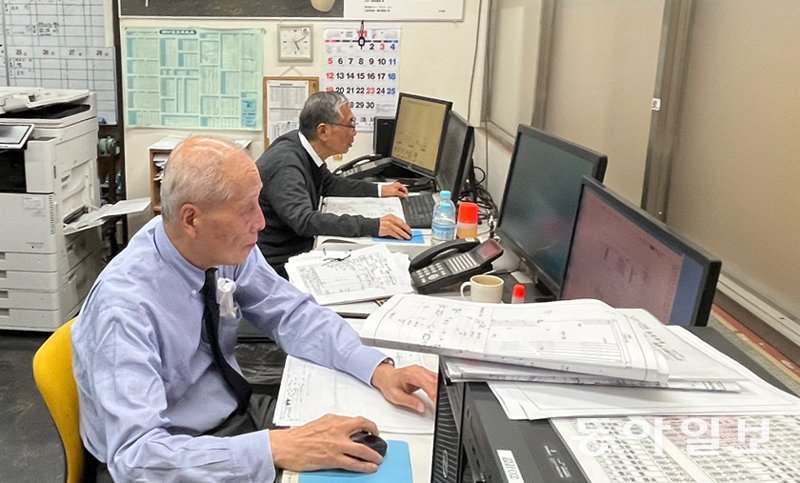 14일 일본 도쿄 아다치구의 특수셔터 제작회사 ‘요코비키셔터’ 사무실에서 셔터 설계 담당자인 가나이 노부하루 씨(왼쪽)가 일하고 있다. 올해 81세인 그는 이 회사 최고령 직원이다. 도쿄=주애진 기자 jaj@donga.com