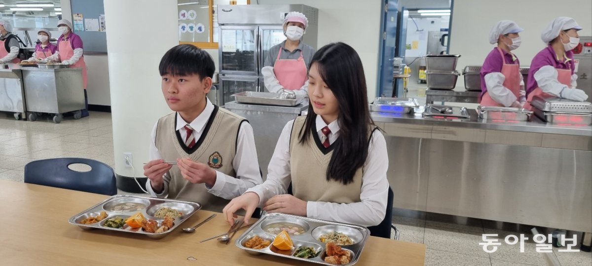 학생들이 22일 서울 성북구 숭곡중 2층 급식실에서 급식 로봇이 조리사들과 함께 조리한 음식을 먹고 있다. 최훈진 기자 choigiza@donga.com
