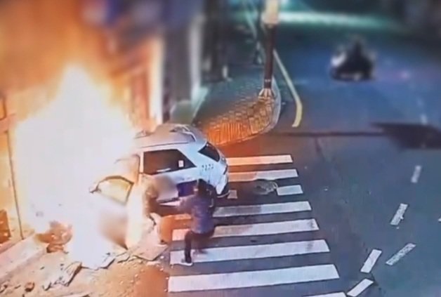 지난 22일 오후 9시40분께 부산 연제구 연산동 한 내리막길에서 전기 택시가 충격으로 화재가 나면서 유세림(34)씨가 택시 기사를 구하는 모습. (부산경찰청 제공)