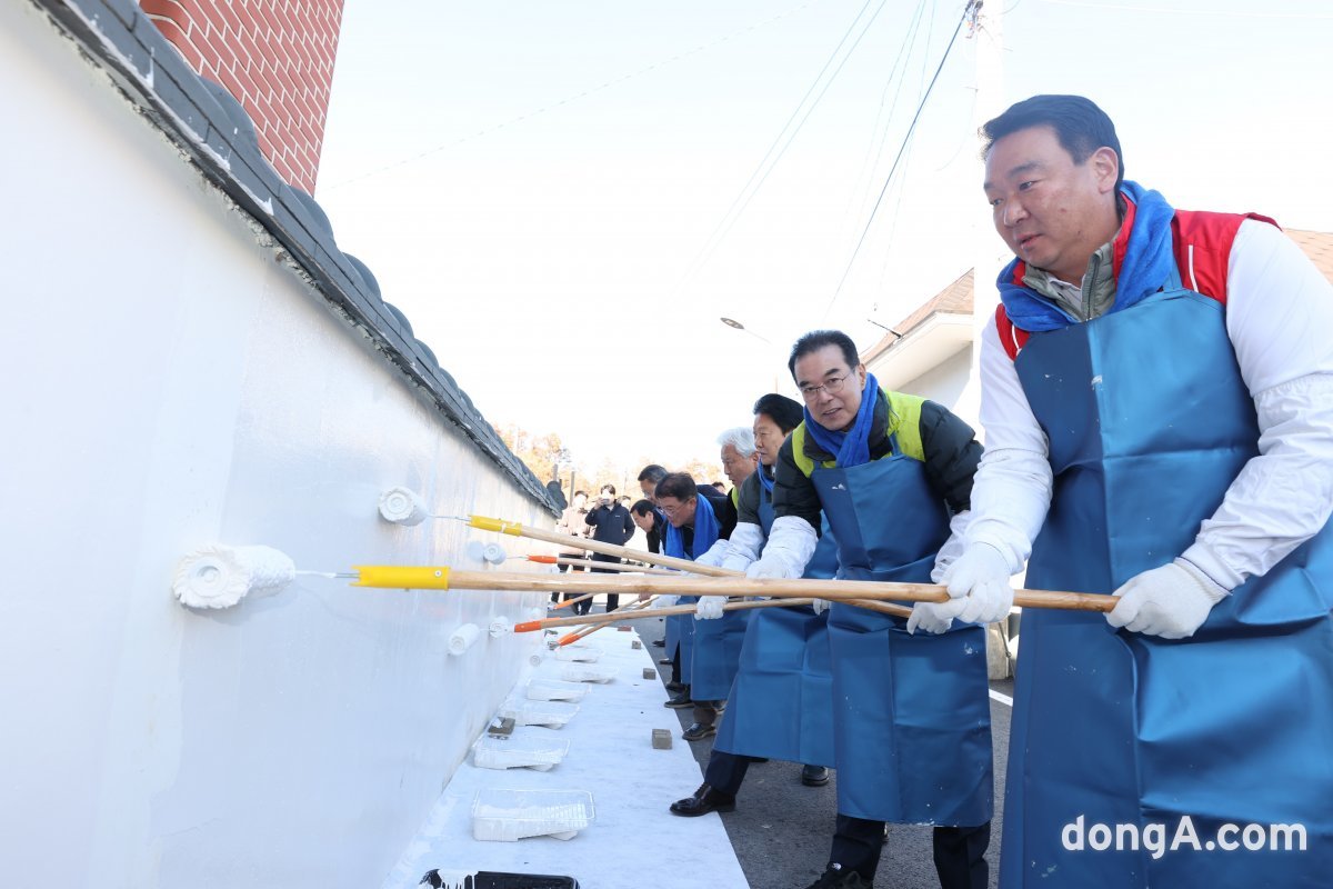 24일 경북 성주군에서 열린 '사랑의 집고치기' 농가희망 봉사활동에서 이성희 농협중앙회장과 참석자들이 담벼락 도장을 하고 있다. 농협 제공