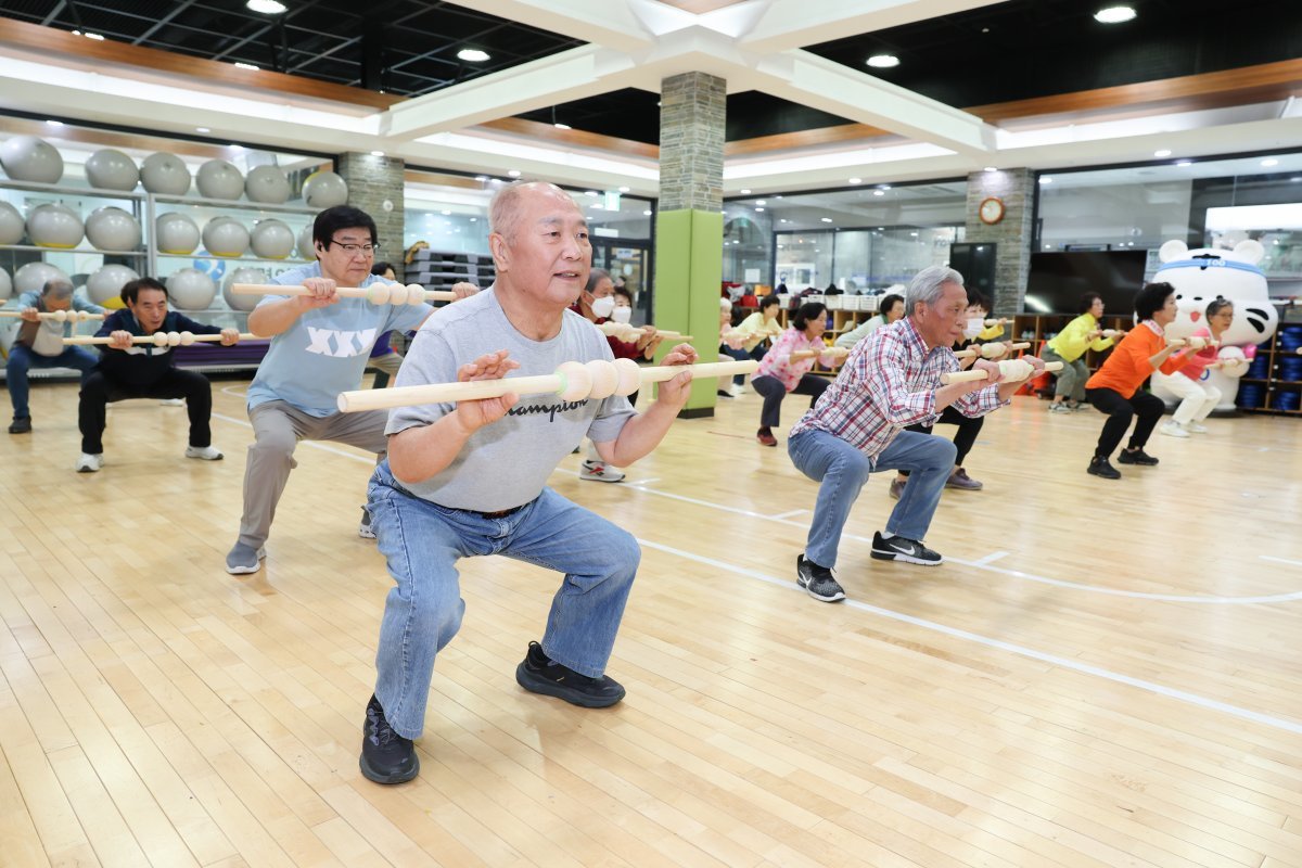 국민체력100 메인센터인 서울 송파체력인증센터에서 65세 이상 남녀  노인들이 봉을 들고 하체 근육운동인 스쾃을 즐겁게 하고 있다. 국민체육진흥공단 제공.