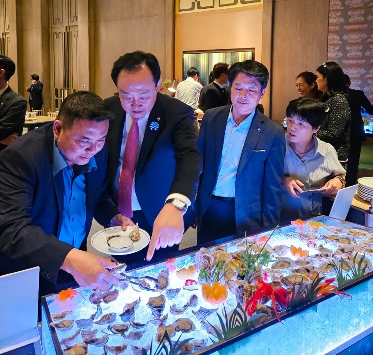 천영기 통영시장(왼쪽에서 두 번째)이 9월 중순 태국 현지 호텔에서 개최한 판촉 행사에서 통영 수산물로 만든 요리를 참가자들에게 설명하고 있다. 통영시 제공