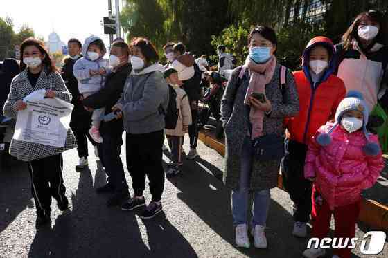지난달 24일(현지시간) 베이징의 한 소아과 병원 앞에서 시민들이 장사진을 치고 있는 모습. ⓒ 로이터=뉴스1