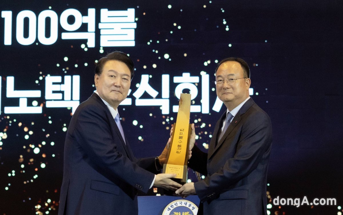 문혁수 LG이노텍 CEO(오른쪽)가 윤석열 대통령으로부터 100억불 수출의 탑을 전달받고 있다.