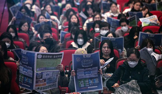 종로학원 2024 수능 결과 및 정시합격점수 예측 설명회에 참석한 학부모들이 정시모집 배치 참고표를 살펴보고 있다. 뉴스1