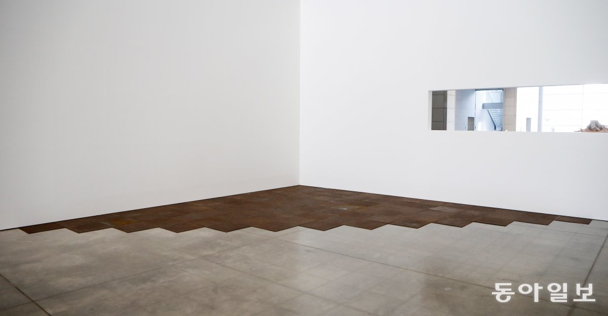 대구미술관 어미홀에서 전시되고 있는 칼 안드레의 작품 ‘Ferox, New York’(1982). 녹슨 철판 91개를 삼각형 모양으로 바닥에 깔았다. 사진: 대구미술관 제공