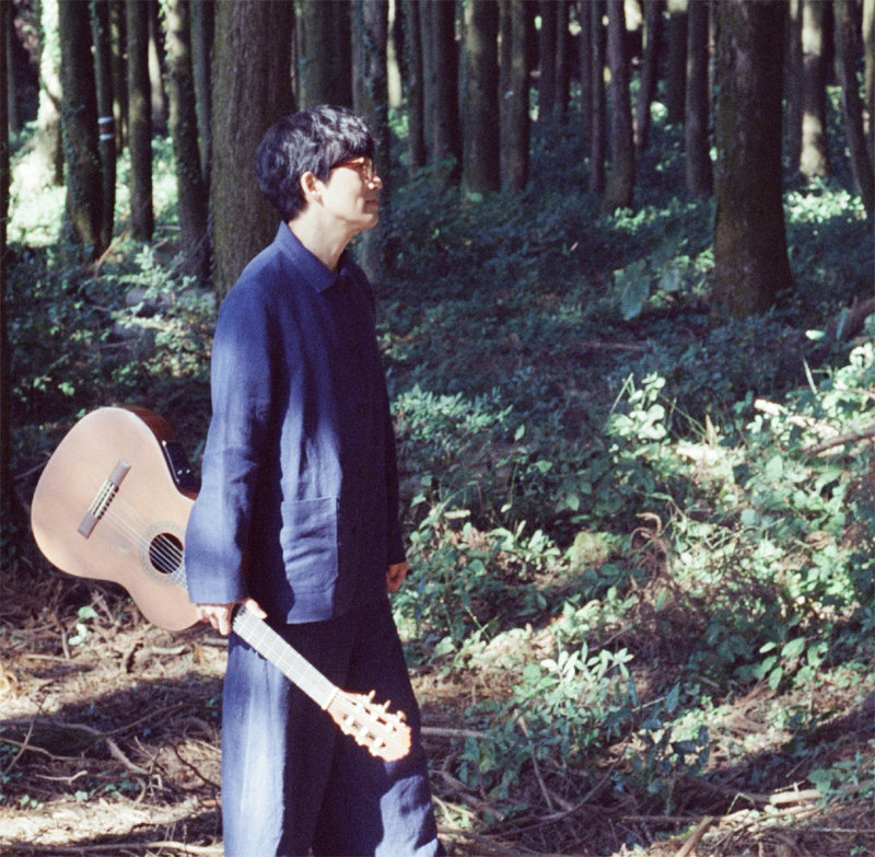 싱어송라이터 루시드폴이 기타를 들고 제주의 숲을 거닐고 있다. 루시드폴 제공