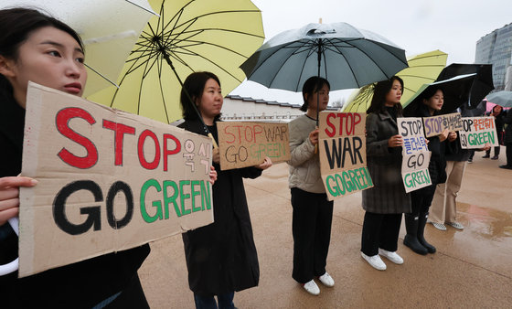 환경재단 관계자들이 서울 종로구 경복궁 앞에서 11일 열린 COP28 기후 위기 해결 촉구 한국 슬로건 캠페인에서 종이박스 피켓 퍼포먼스를 하고 있다. /뉴스1