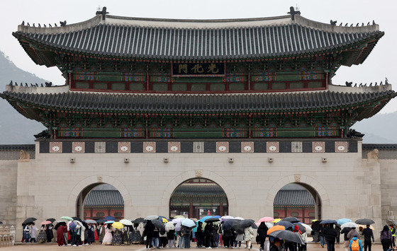 겨울비가 내리는 14일 오전 서울 종로구 광화문에서 우산을 쓴 관람객들이 발걸음을 옮기고 있다. 2023.12.14/뉴스1 ⓒ News1