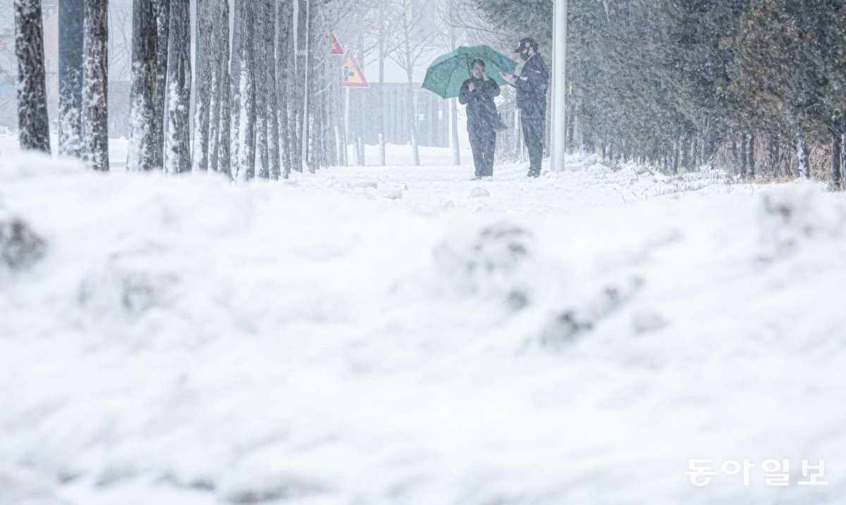 15일 눈이 가득 쌓인 대관령면 시내에서 한 시민이 우산을 쓴 채 버스를 기다리고 있다. 박형기 기자 oneshot@donga.com