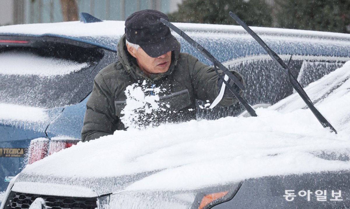 15일 대관령면의 아파트 단지 주차장에서 한 주민이 차에 얼어붙은 눈을 제거하고 있다. 박형기 기자 oneshot@donga.com