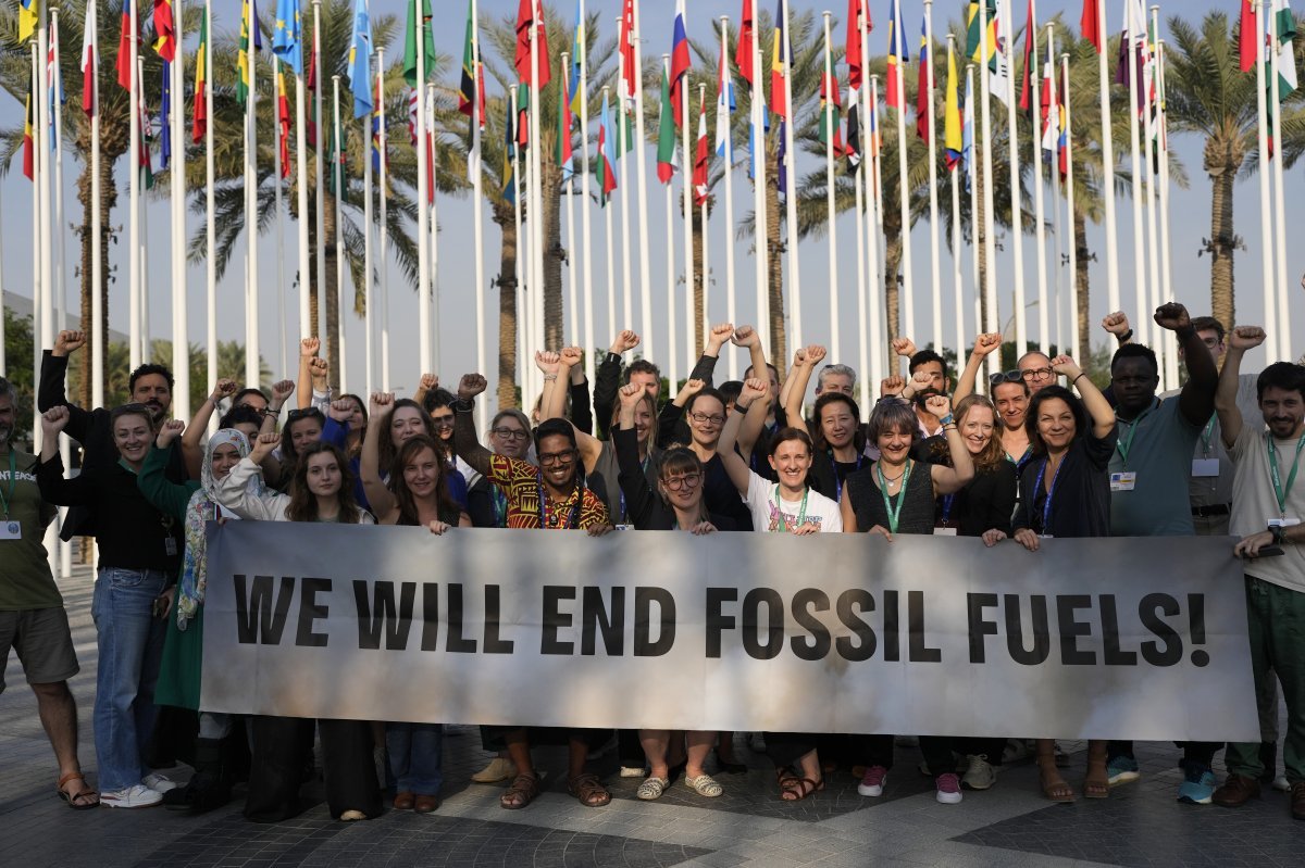 COP28이 폐막한 13일(현지시간) 두바이에서 국제환경단체 그린피스 회원들이 “우리는 화석 연료를 끝낼 것이다”는 내용의 플랜카드를 들고 서있다.  AP 뉴시스