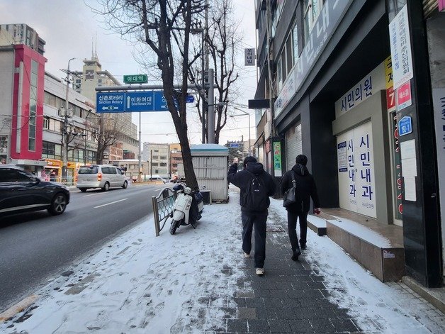 신촌역 근처에서 행인들이 조심스럽게 걷고 있다.