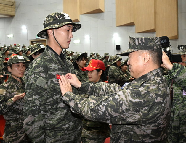 육상 높이뛰기 국가대표 우상혁(왼쪽)이 20일 포항 해병대 1사단에서 열린 ‘원 팀 코리아 캠프’ 수료식에서 해병대 상징인 빨간 명찰을 달고 있다. 대한체육회 제공