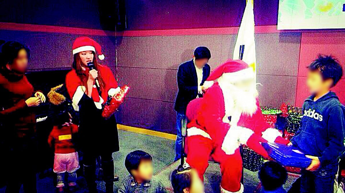 2013년 12월 한국미혼모가족협회 송년회 당시 한 산타가 미혼모 자녀들에게 선물을 전달하는 모습. 마이크를 잡은 여성이 프로젝트를 처음 시작한 섀넌 하이트 씨다. 섀넌 씨 제공