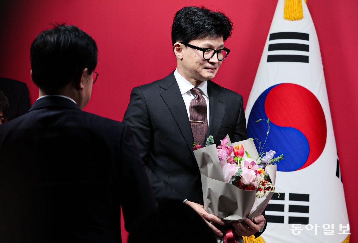 26일 한 위원장이 당 관계자로부터 축하 꽃다발을 받고 취임식장을 나서고 있다. 박형기 기자 oneshot@donga.com