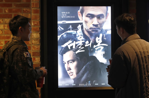 크리스마스인 25일 오후 서울의 한 영화관을 찾은 시민들이 12·12 군사쿠데타를 다룬 영화 ‘서울의 봄’(감독 김성수) 포스터를 바라보고 있다. 2023.12.25/뉴스1