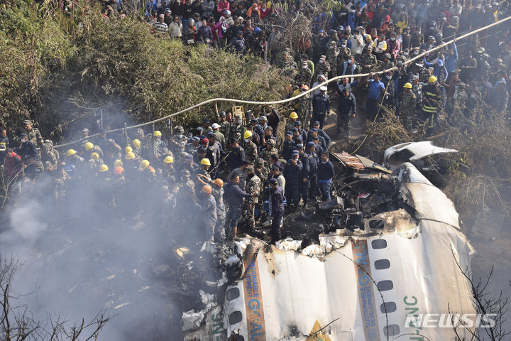 [포카라=AP/뉴시스] 네팔 구조대원들과 민간인들이 네팔 포카라 인근에 추락한 여객기 잔해에 모여있다. 2023.01.15.
