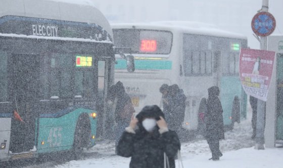 많은 눈이 내린 22일 오전 제주시 연동 거리에서 시민들이 출근길 버스를 타고 있다. 이날 제주는 전날에 이어 전역에 대설특보가 내려졌다. 2023.12.22. 뉴스1