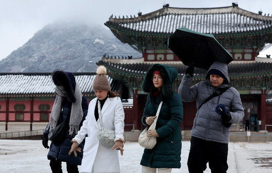 아침까지 약한 눈비가 이어진 31일 오전 서울 종로구 경복궁을 찾은 관광객이 설경을 바라보고 있다. 2023.12.31/뉴스1 ⓒ News1