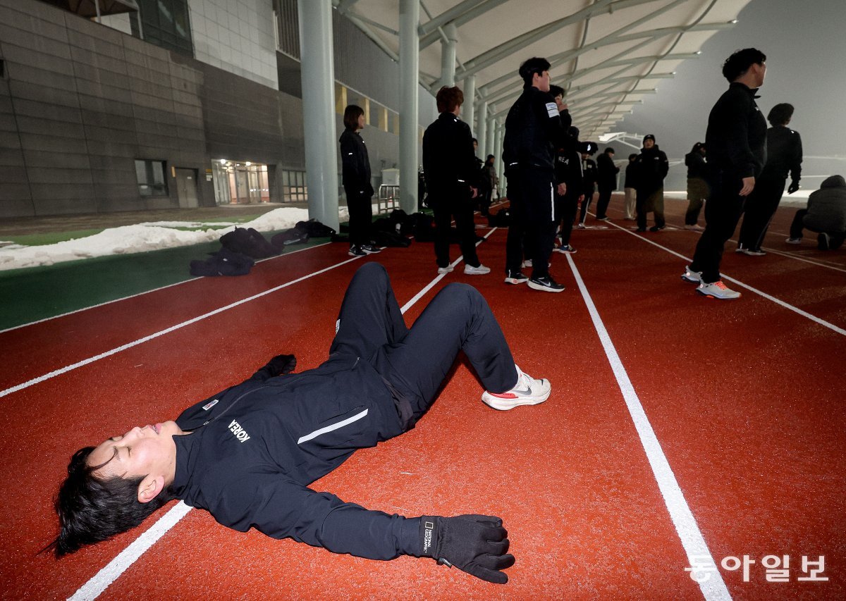 전력 질주 후 지친 한 국가대표 선수가 누워서 숨을 고르고 일다.