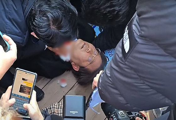 이재명 더불어민주당 대표가 2일 오전 부산 가덕도에서 신원미상인에게 습격을 당한 뒤 쓰러져 있다. (유튜브 정일영 TV 캡처) 2024.1.2/뉴스1